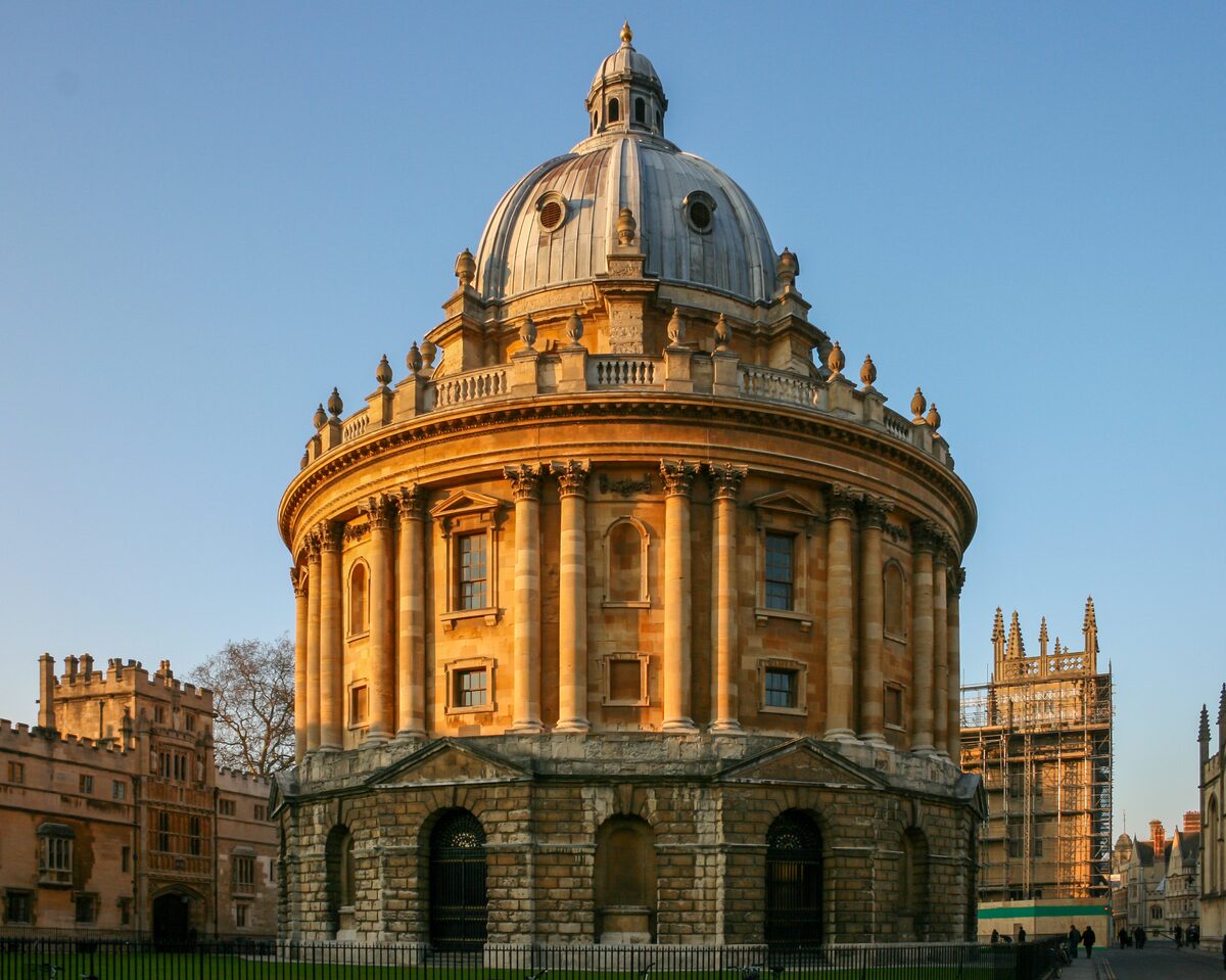 The round, domed Radcliffe Camera in Oxford, with stone columns and a cupola, in the middle of Radcliffe Square