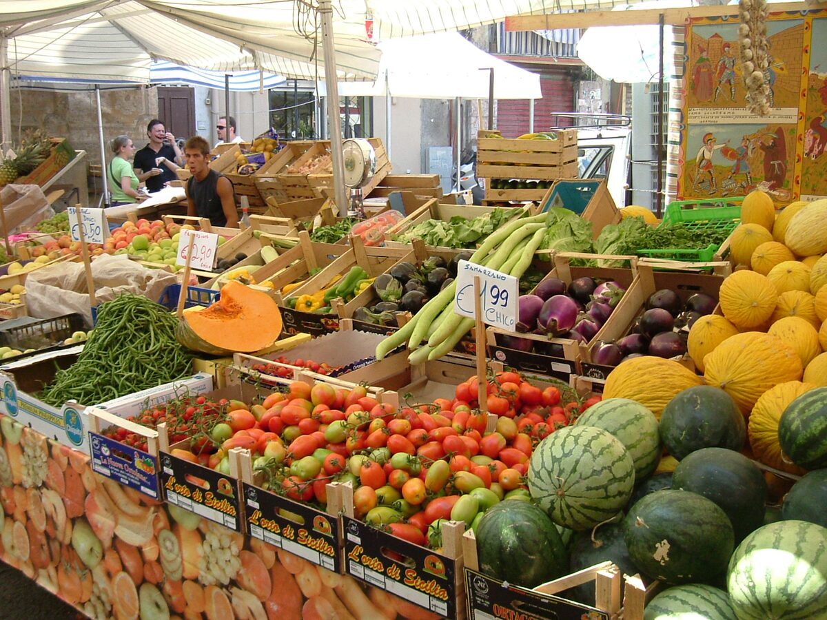 A Ballarò produce stall with tomatoes, melons, watermelons and green beans