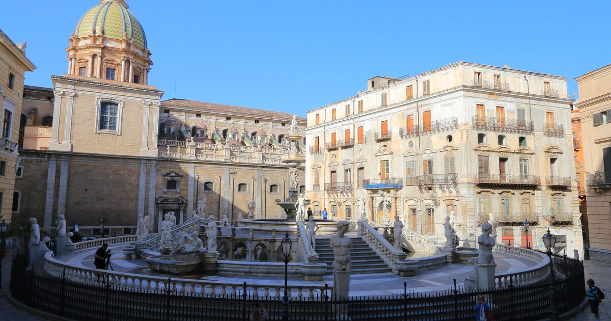 The Pretoria fountain and the tiled dome of San Giuseppe dei Teatini under a blue sky