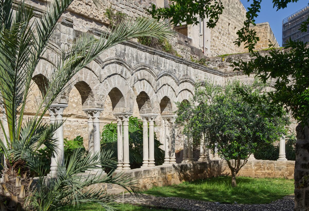The arched cloister of San Giovanni degli Eremiti among palms and orange trees