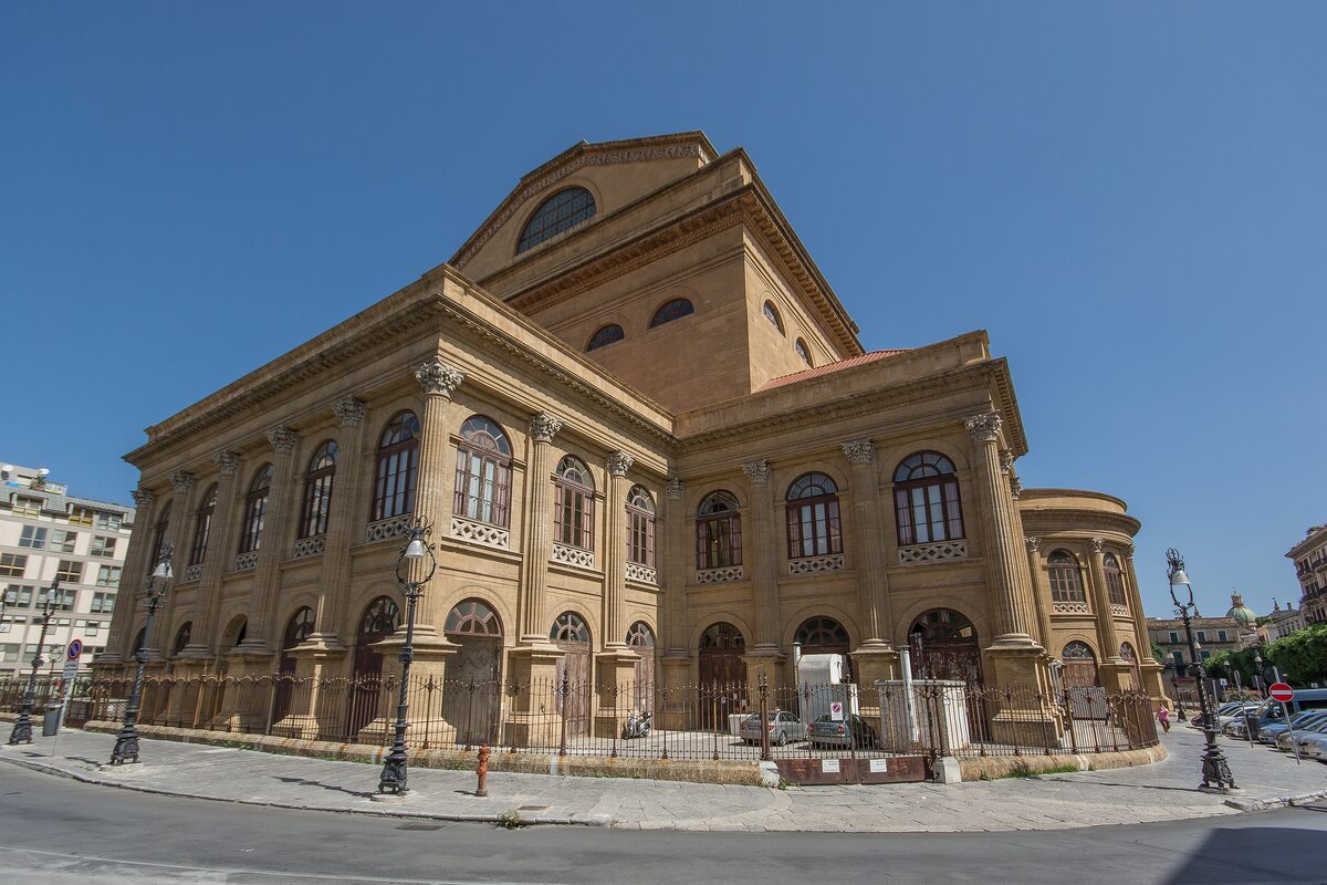 The sandstone side of the Teatro Massimo opera house under a blue sky