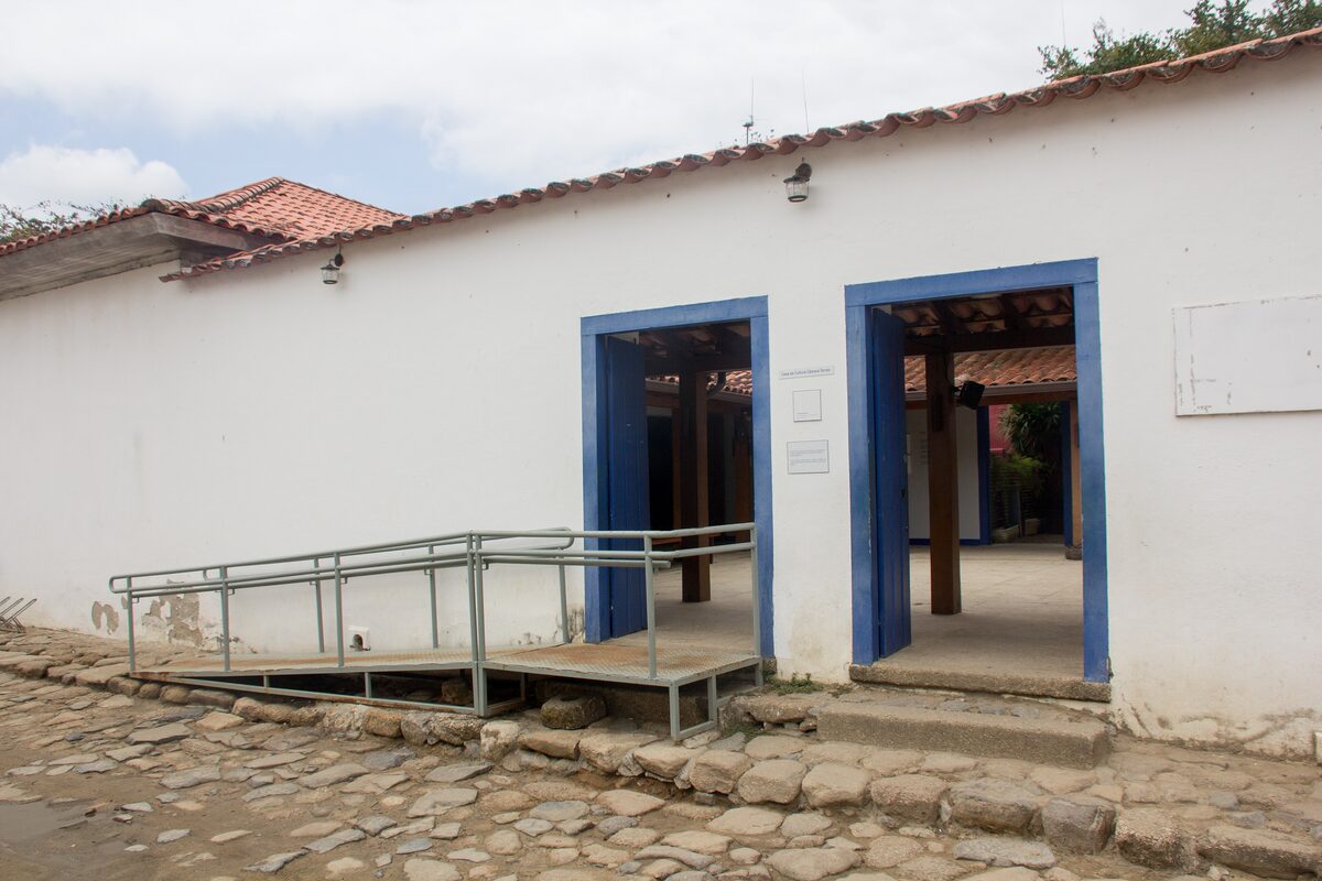 The whitewashed Casa da Cultura in Paraty with blue door frames, seen from the cobbled street