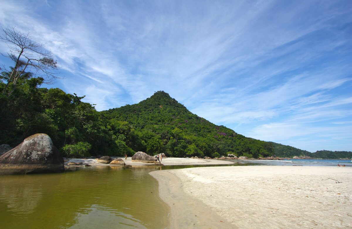 Pale sand and a granite outcrop with green water at Dois Rios on Ilha Grande