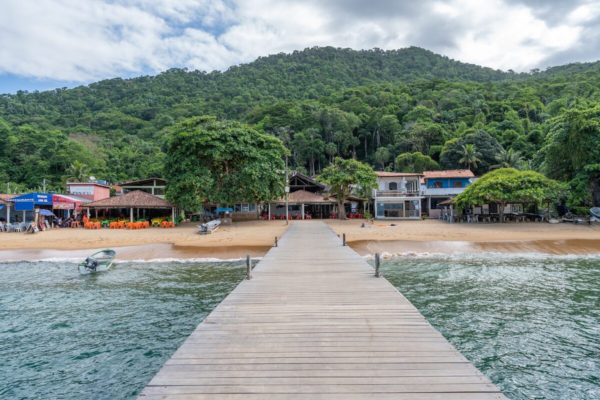 The wooden pier at Lagoa Azul on Ilha Grande, with the beach and bars behind