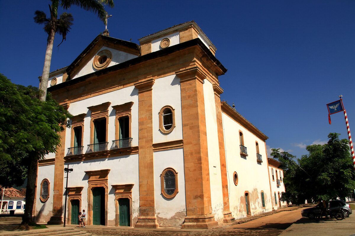 The ochre and white facade of the Igreja Matriz de Nossa Senhora dos Remédios on a sunny square