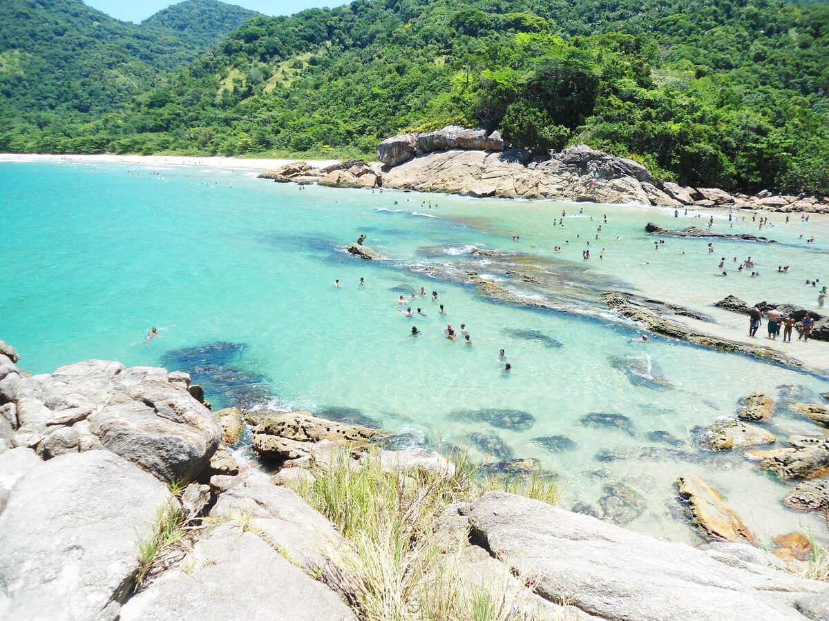 Turquoise water, swimmers and granite boulders on a beach in Trindade near Paraty
