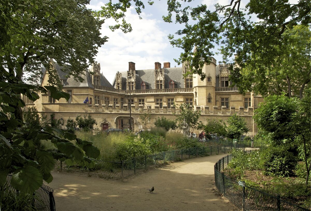 The pointed gables and turrets of the Hôtel de Cluny, home of the Musée de Cluny, seen across a garden path