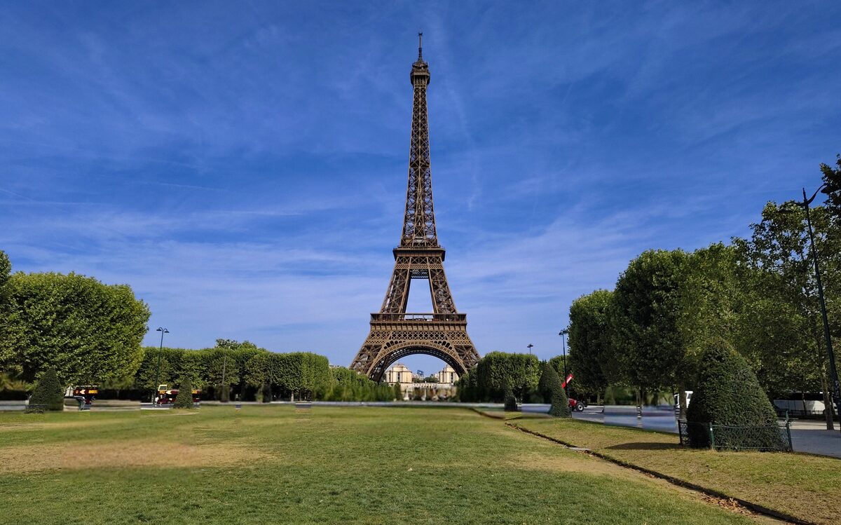 The Eiffel Tower in daylight from the Champ de Mars, with the lawns and trees in front