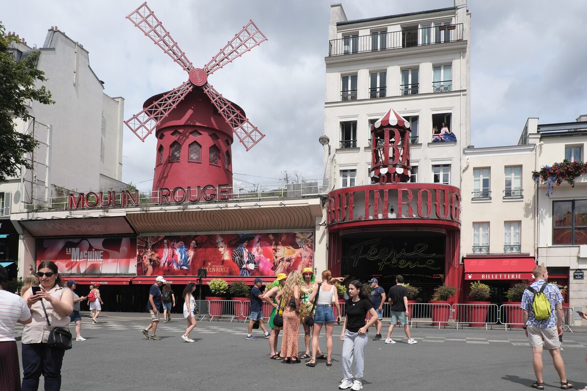 The red windmill and the Moulin Rouge entrance on Boulevard de Clichy, with crowds in front