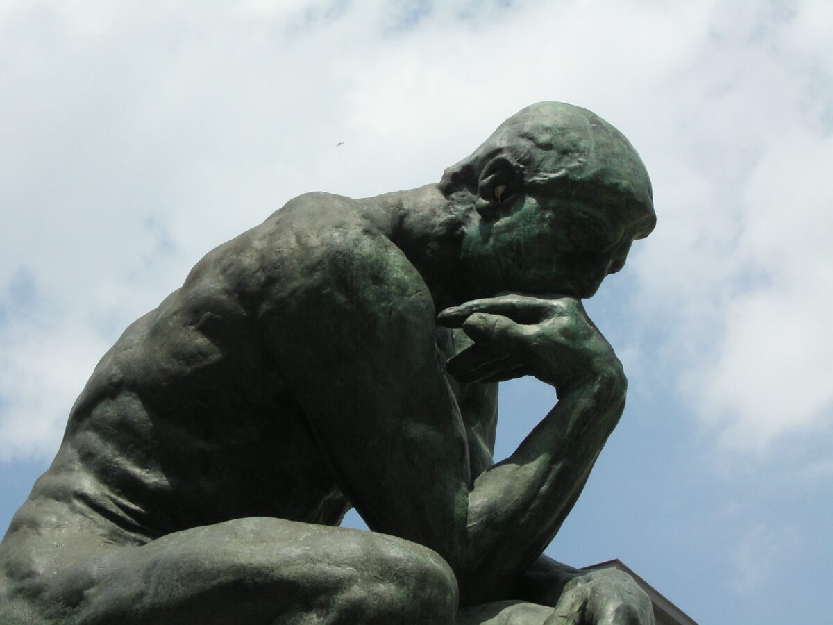 Rodin's bronze The Thinker, shot close against a pale sky