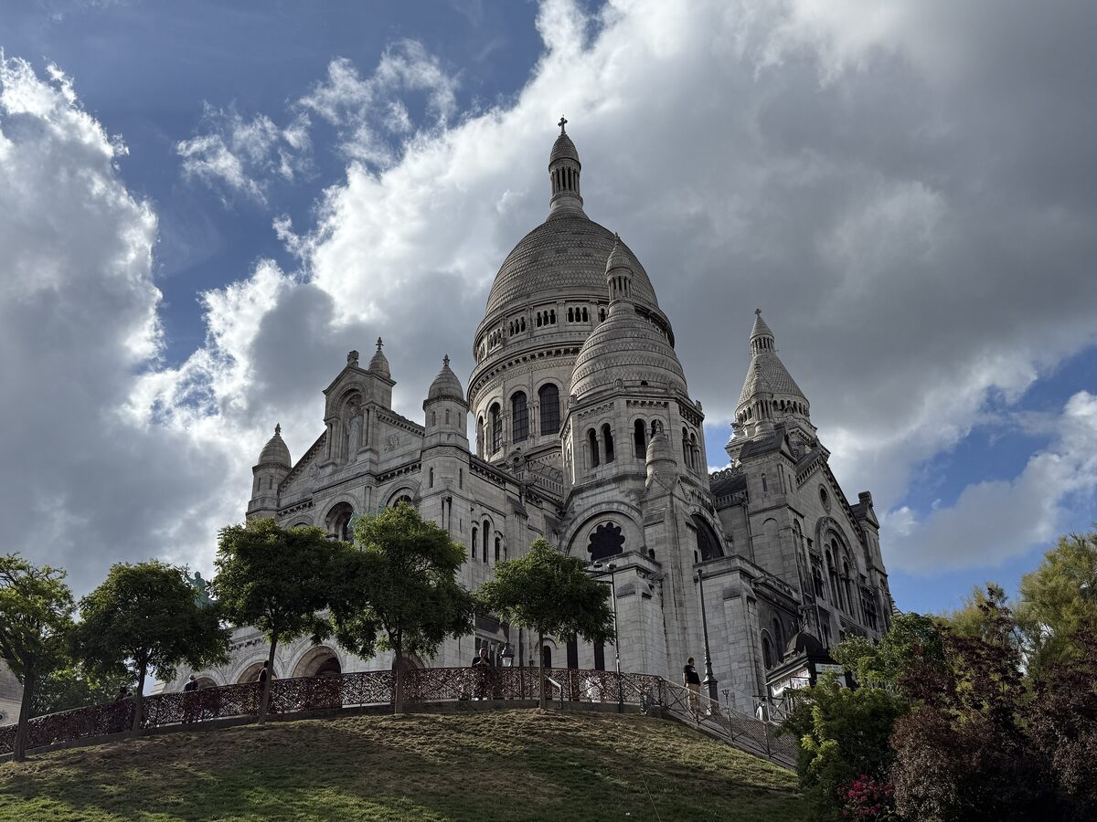 The white domes of the Sacré-Cœur basilica on Montmartre under a cloudy sky
