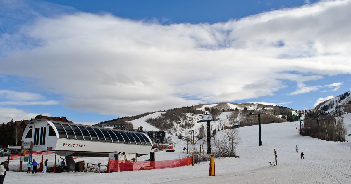 Snow-covered runs and a chairlift station at Park City Mountain, with skiers on the piste
