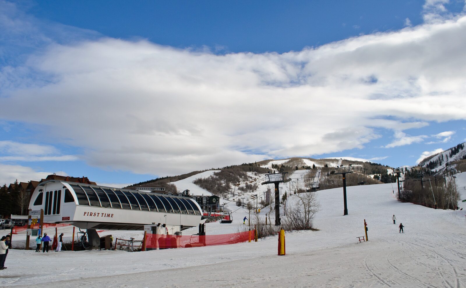 Snow-covered runs and a chairlift station at Park City Mountain, with skiers on the piste