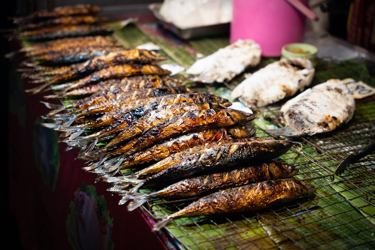 Grilled fish on banana leaves at a food stall in Patong market