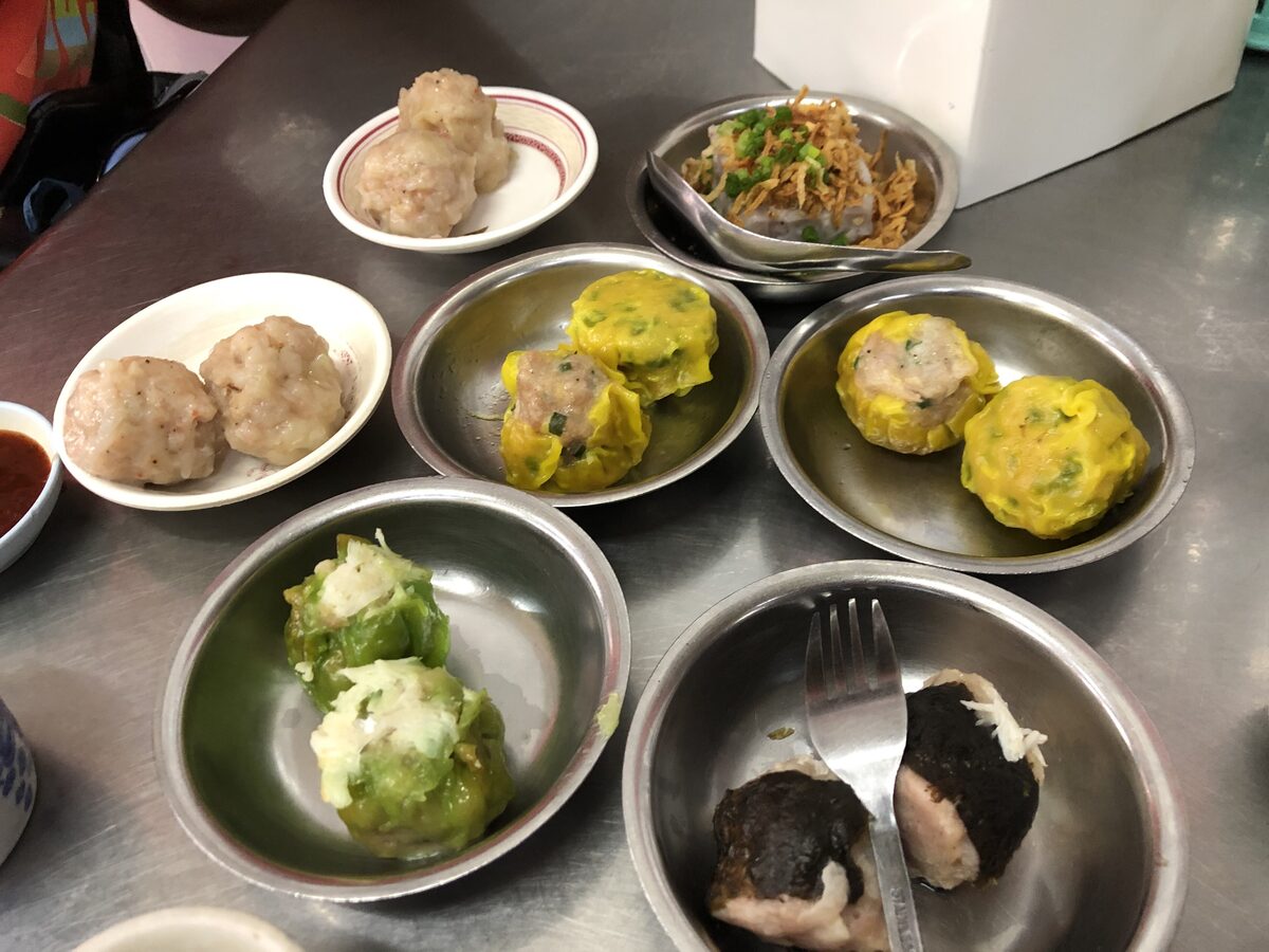 Steamed dumplings and buns on steel trays at a dim sum stall in Phuket Town