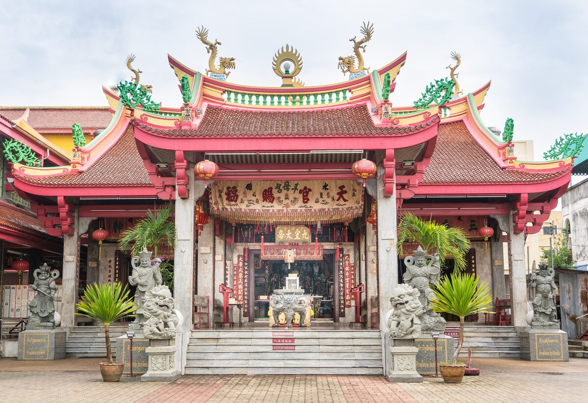 The red-and-gold roofed front hall of the Jui Tui Shrine in Phuket Town, with stone lions and lanterns at the entrance
