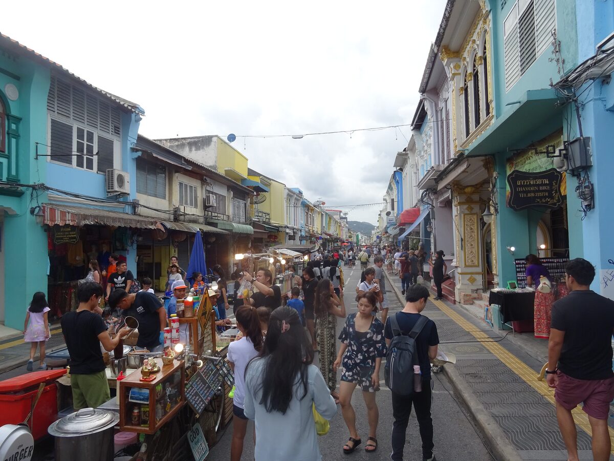 Shoppers and food stalls crowd the colorful Sunday walking street of Phuket Old Town