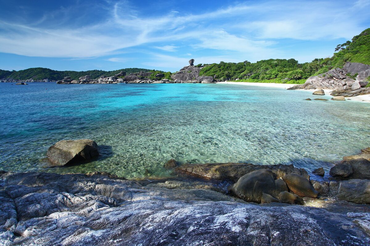 Clear turquoise water and granite boulders on a beach in the Similan Islands