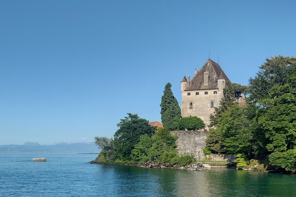 The medieval castle of Yvoire on a wooded point above the blue water of Lake Geneva