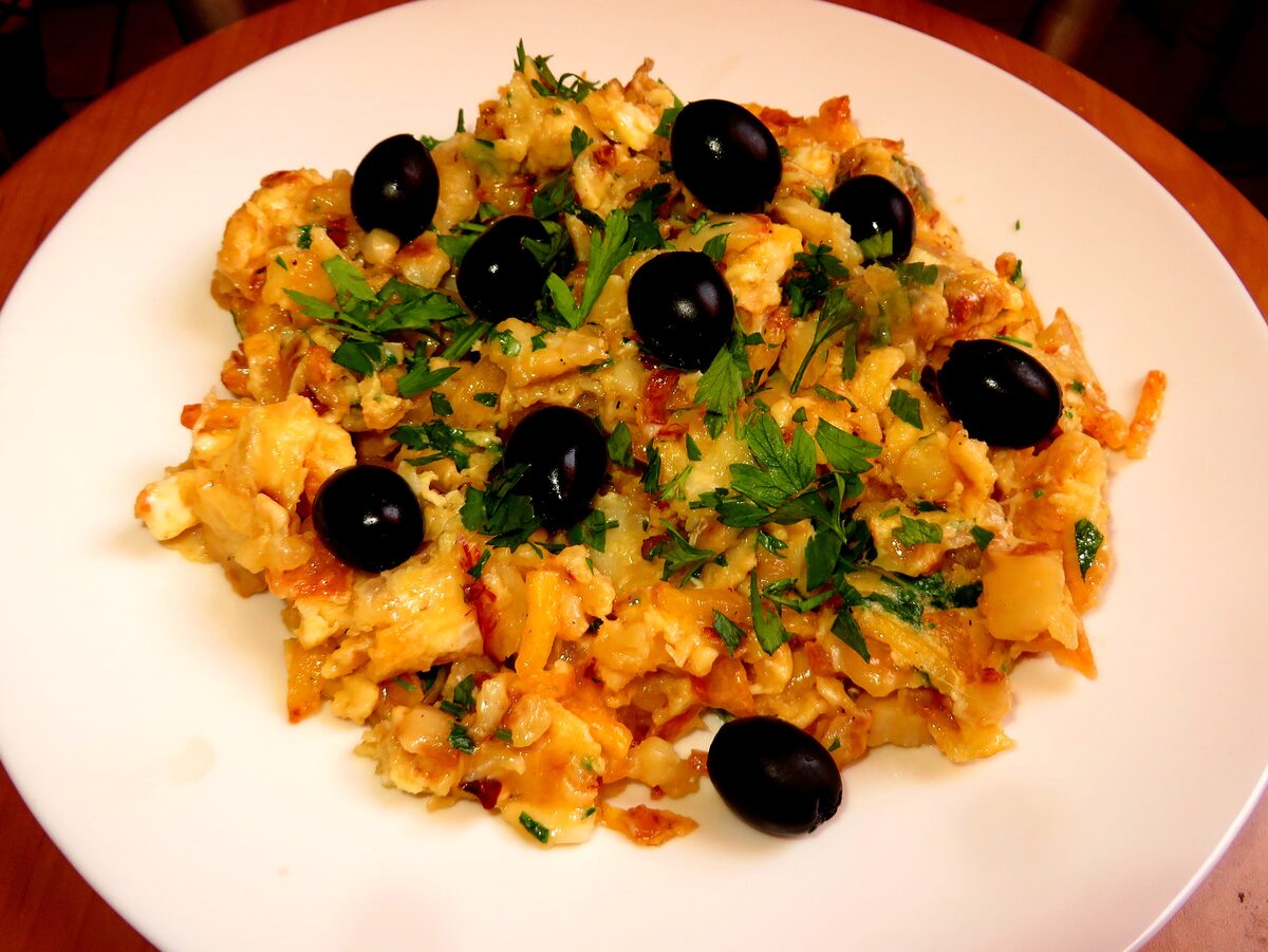 Bacalhau à Brás, shredded salt cod scrambled with egg and potato, topped with black olives