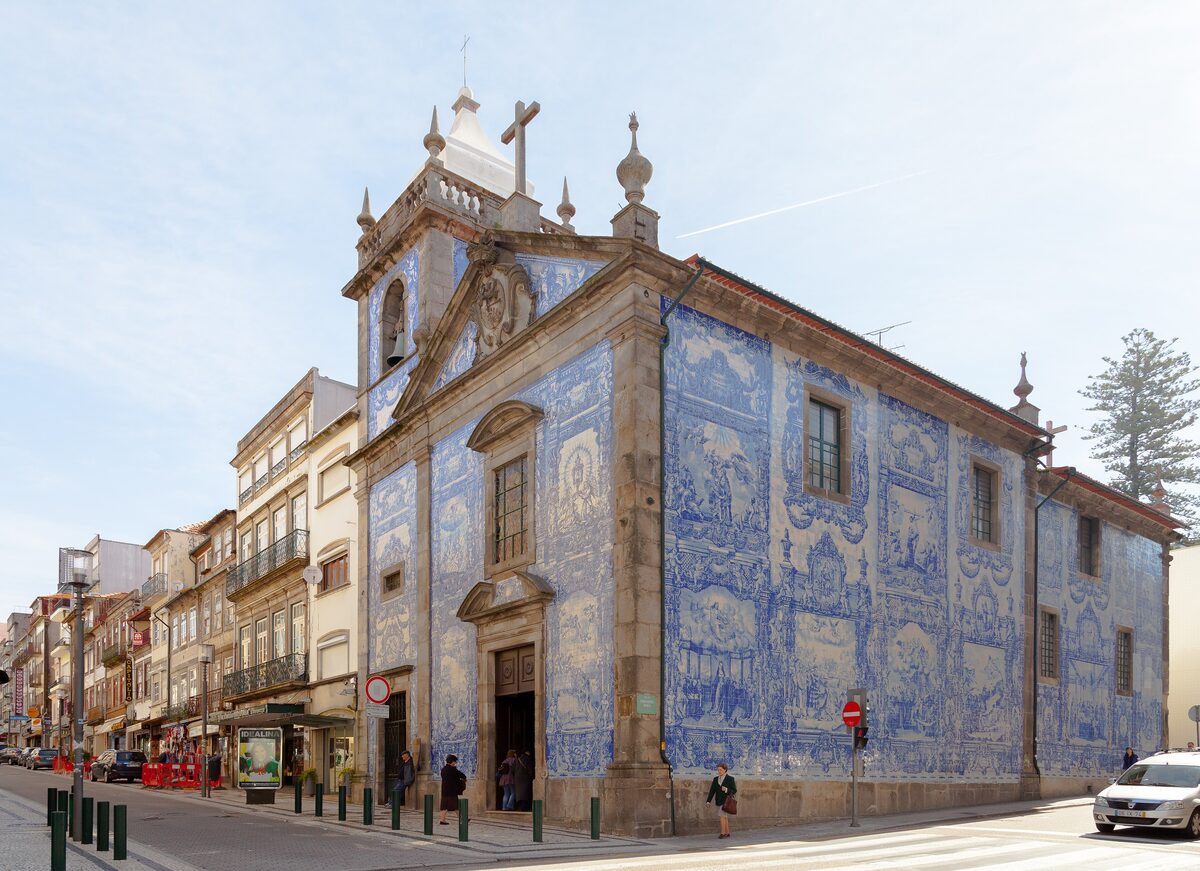 The Capela das Almas chapel covered in blue and white azulejo tiles on a city street