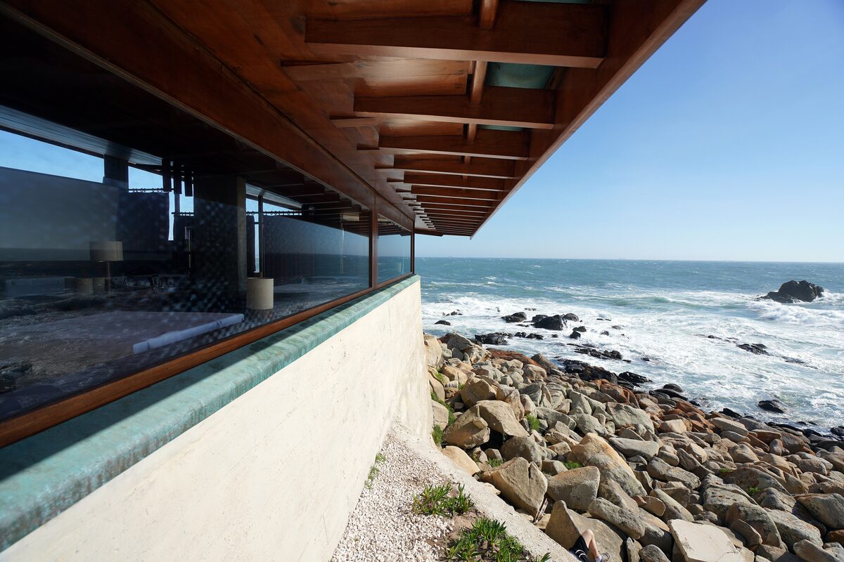 The timber roof overhang and glass wall of Álvaro Siza's Casa de Chá da Boa Nova, built low on the rocks above the Atlantic