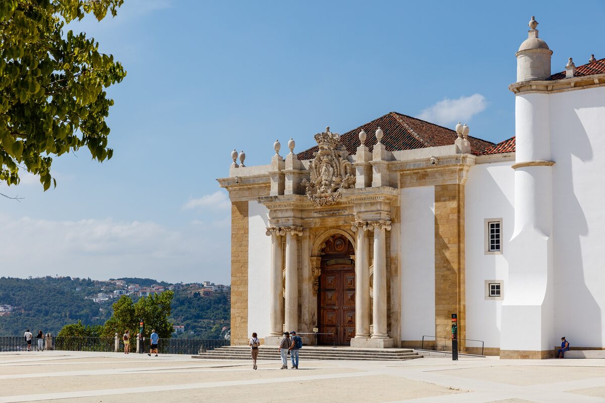 The Baroque entrance to the Joanina Library at the University of Coimbra, with columns and a wooden door