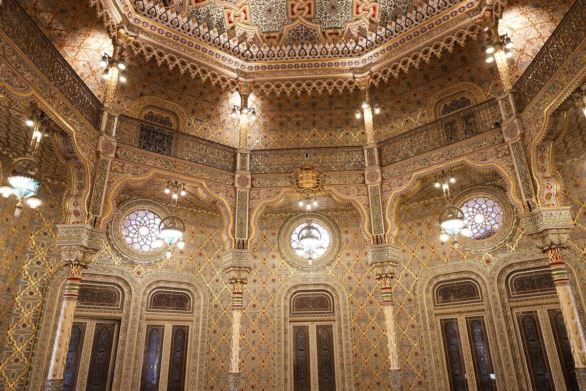 The octagonal Arab Room of the Palácio da Bolsa, with gilded stucco walls, arched windows and a patterned ceiling dome