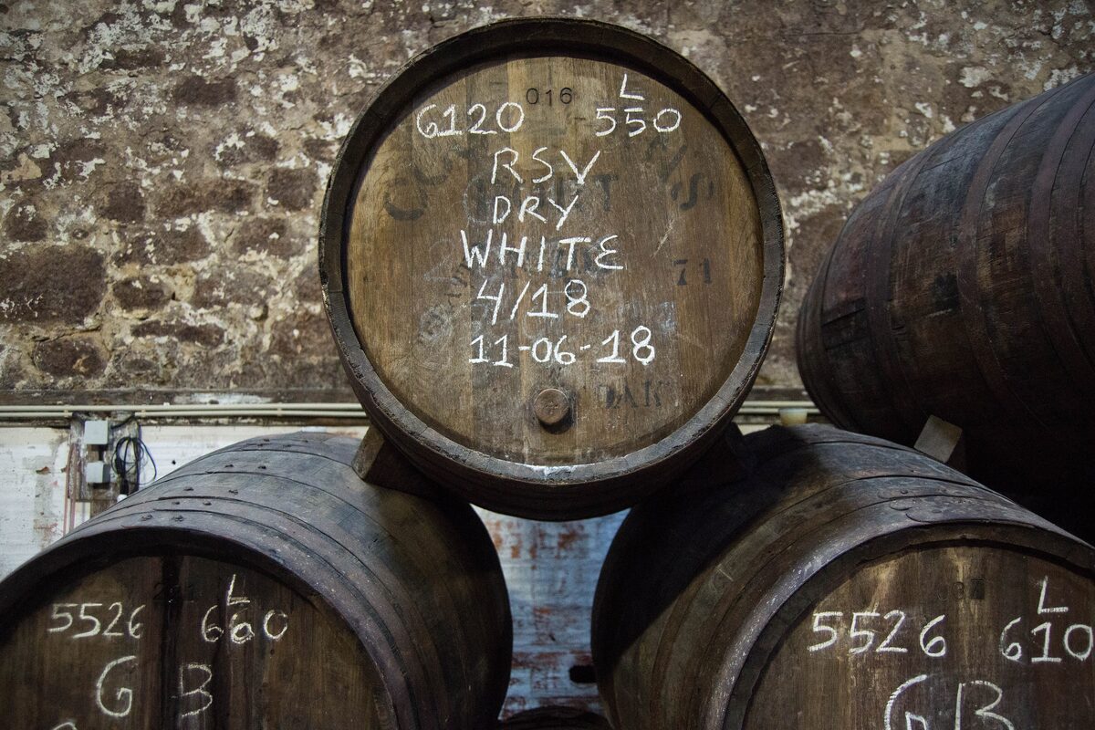 Old oak casks in a port wine cellar, marked in chalk with dates and batch numbers