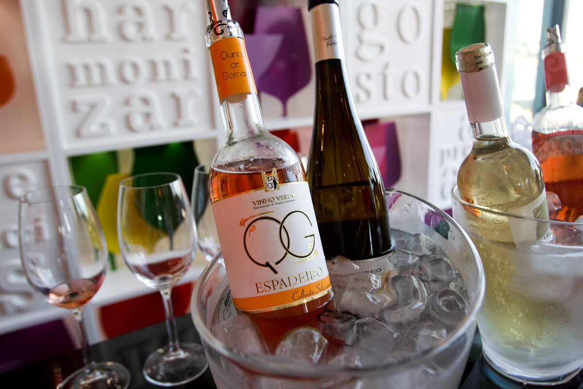 Chilled bottles of Vinho Verde, rosé and white, in an ice bucket with wine glasses beside them