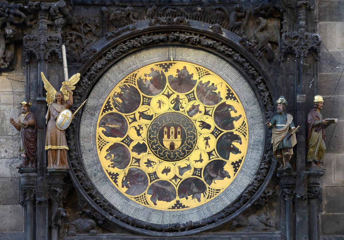 The Astronomical Clock dial with its gold zodiac ring and the carved figures beside it on the Old Town Hall tower