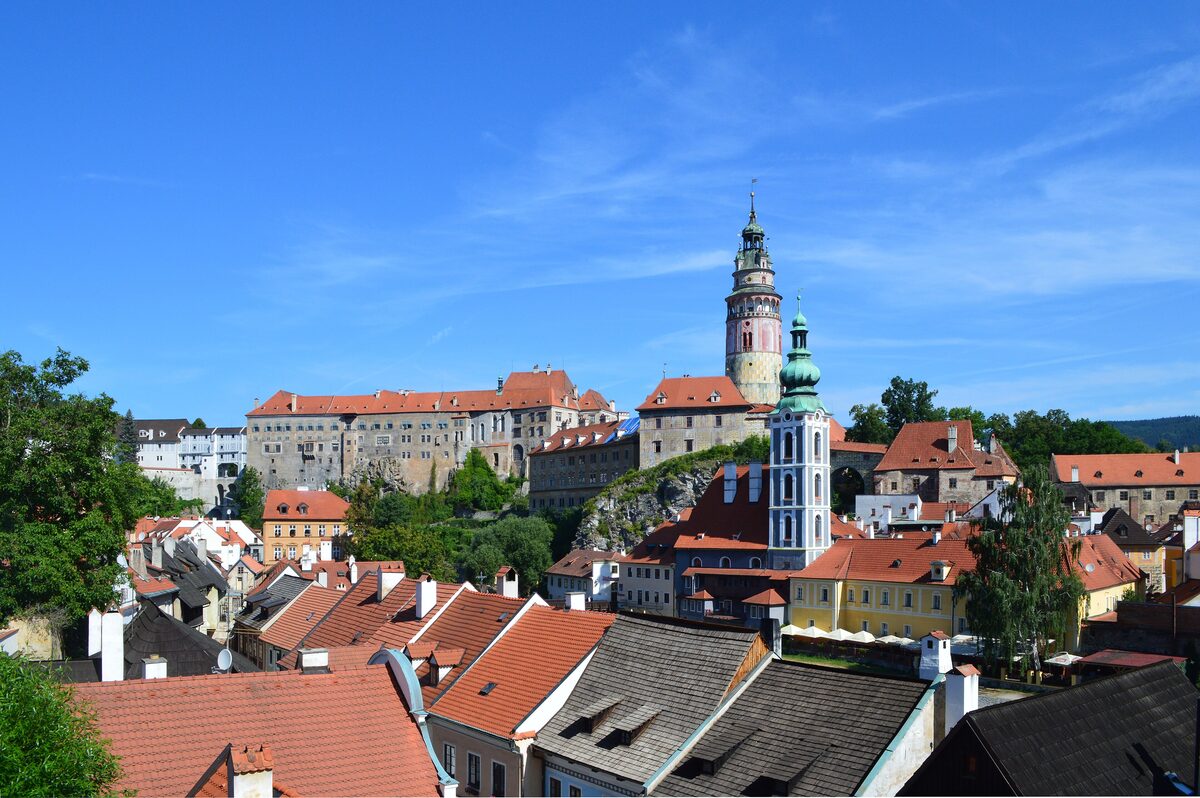 The old town roofs of Český Krumlov and the castle tower above the Vltava on a sunny day