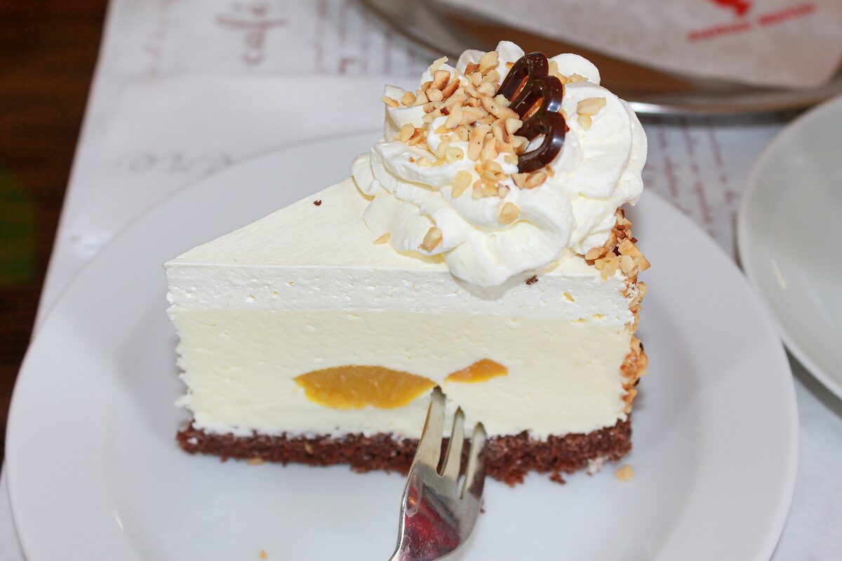 A slice of cheesecake with whipped cream and nuts at Cafe Louvre