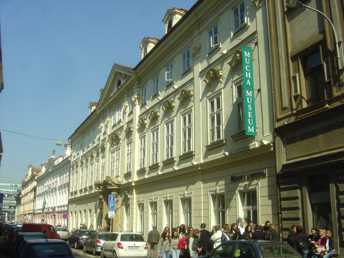 The Mucha Museum building on Panská street with its green sign and ornate Baroque facade