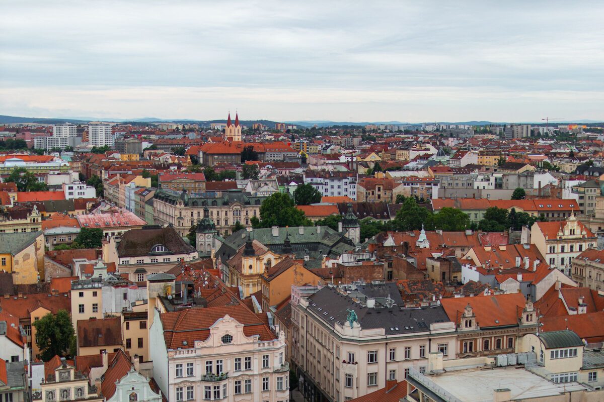 Aerial view of Plzeň's red-roofed old town with a church spire on the skyline