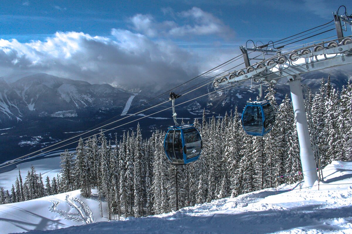 Gondola cabins rising over snow-covered forest on Mount Mackenzie