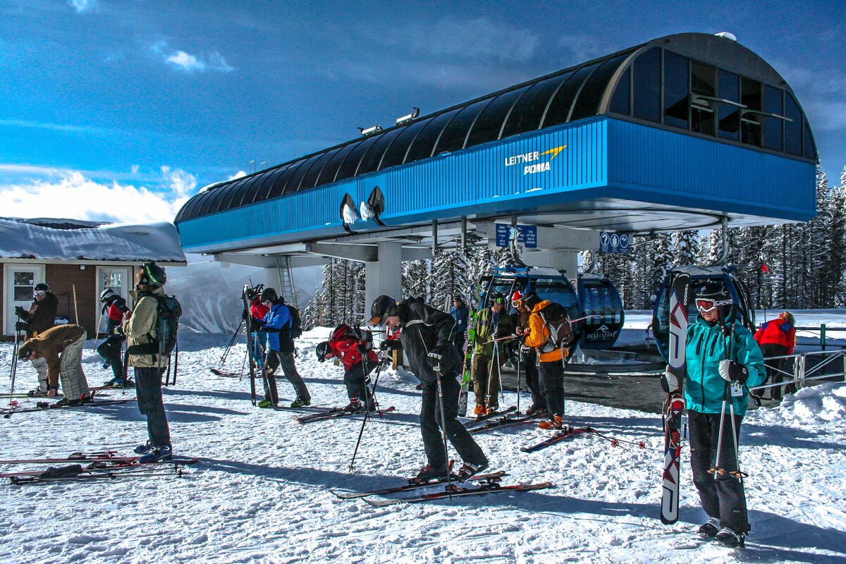 Skiers queue at the blue top station of the gondola