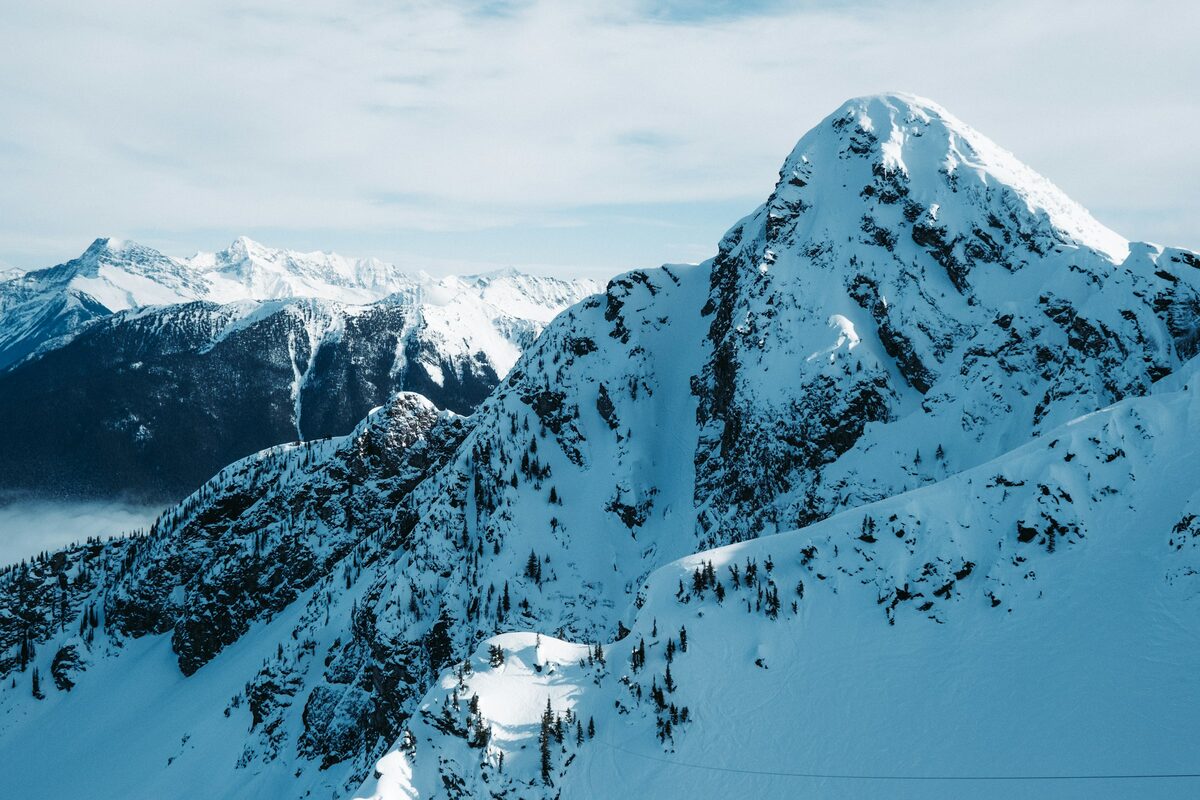 Jagged snow peaks catching light above a sea of cloud