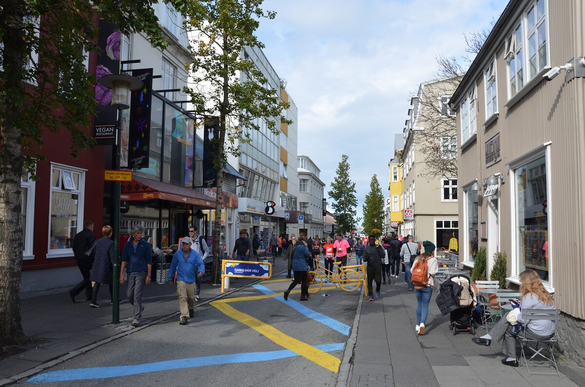 Pedestrians on Laugavegur, the main shopping street, with blue and yellow lines painted on the road