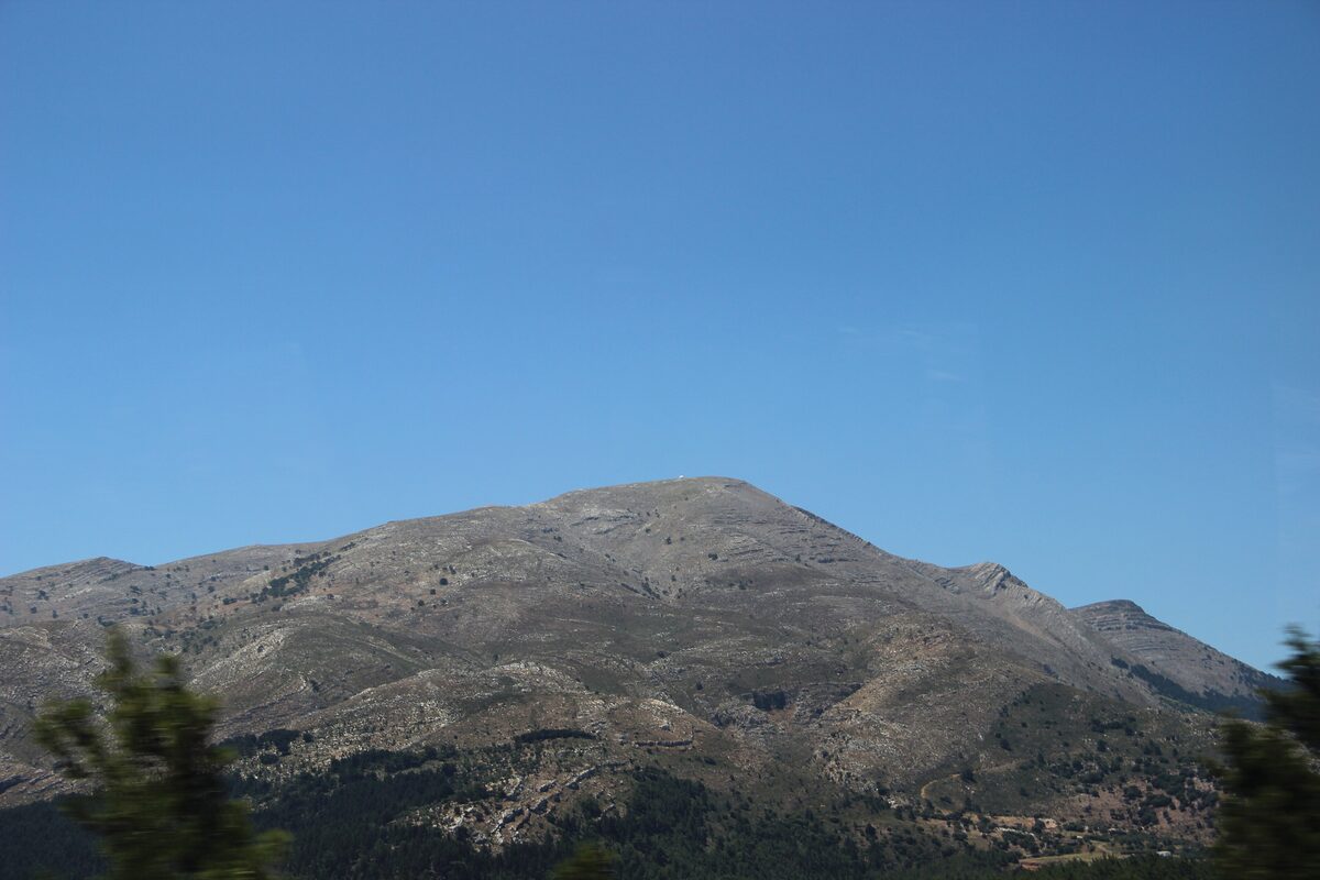 The bare, rocky slopes of Mount Attavyros under a clear blue sky, seen from Emponas