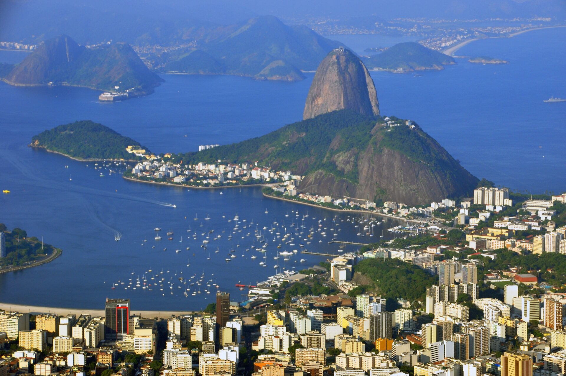 Sugarloaf rising from Guanabara Bay, with the curve of Botafogo bay, its boats and the city below, seen from Christ the Redeemer on a clear day