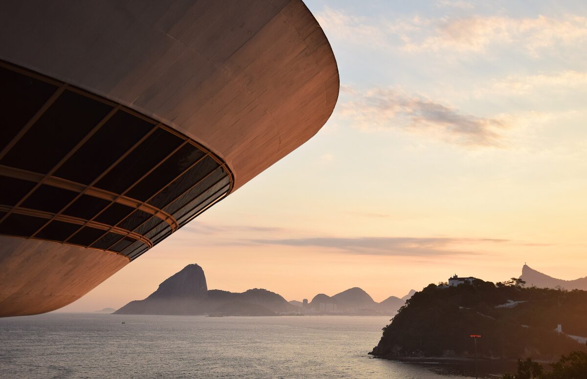 The curved concrete base of the Niterói Contemporary Art Museum over the bay at sunset