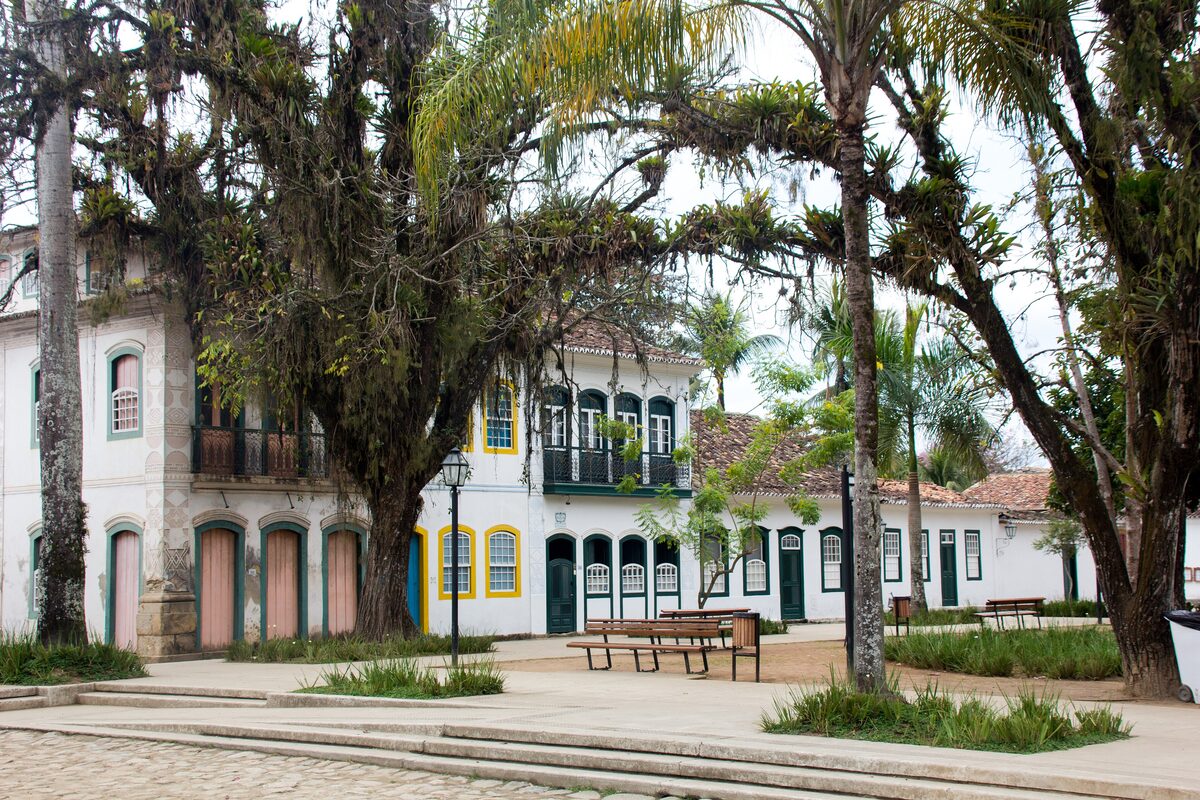 Colonial houses and tall trees on a square in the historic center of Paraty