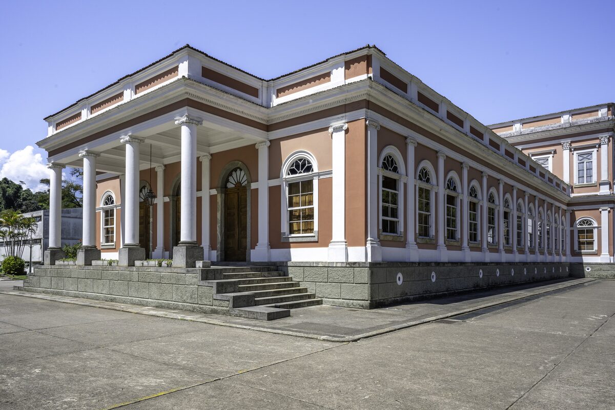 The long pale facade and columns of the Imperial Museum in Petrópolis under a blue sky