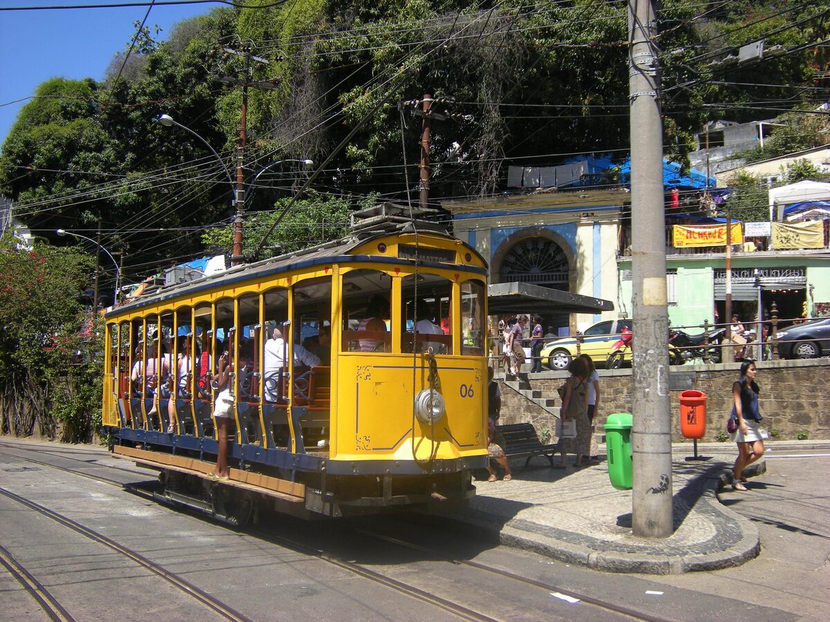 A yellow Santa Teresa tram on the street at Largo do Guimarães