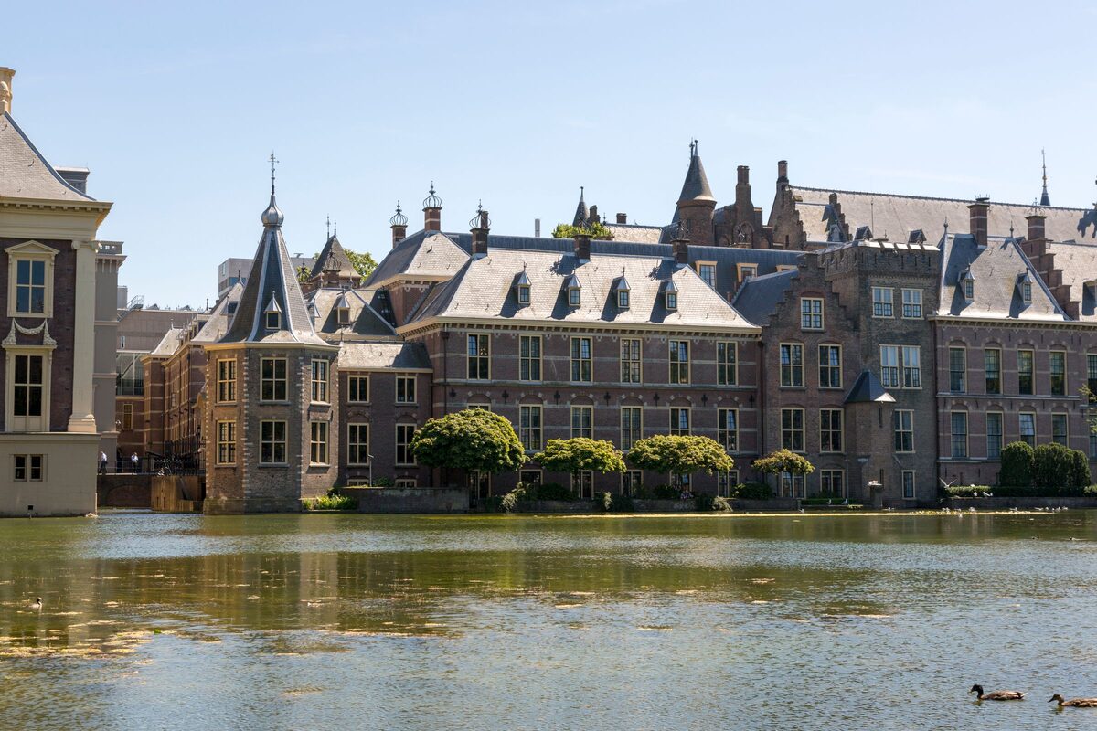 The towers and roofs of the Binnenhof parliament complex reflected in the Hofvijver pond in The Hague