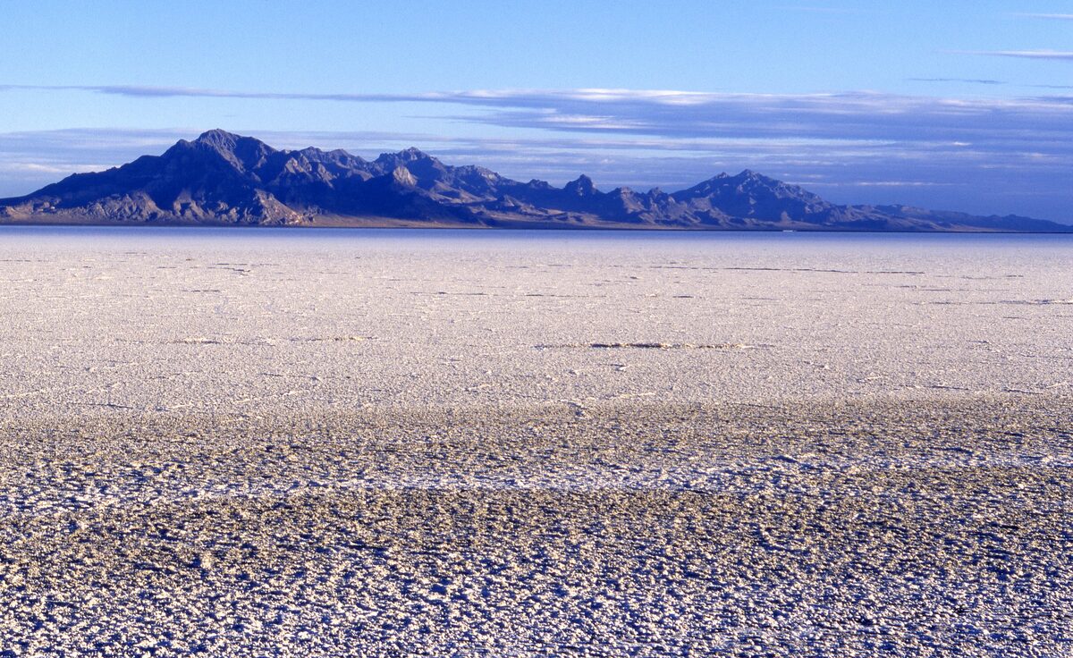 The white, crusted salt pan of the Bonneville Salt Flats stretching to a distant mountain range