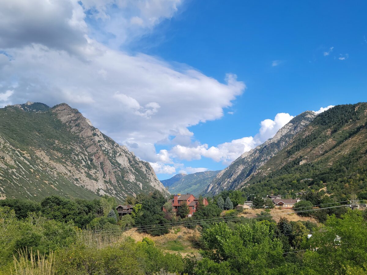 Little Cottonwood Canyon opening from the valley in summer, with steep granite walls and the first homes at its mouth