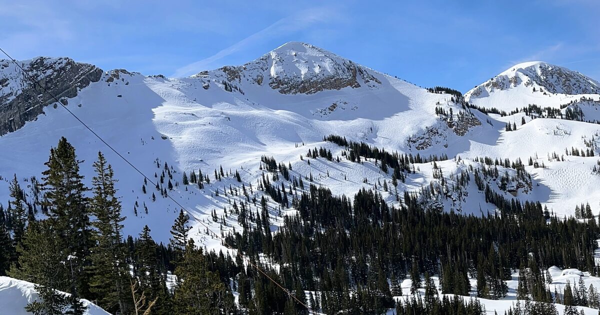 Snow-covered Sugarloaf Mountain and the slopes of Alta under a blue sky, in the Wasatch Range above Little Cottonwood Canyon