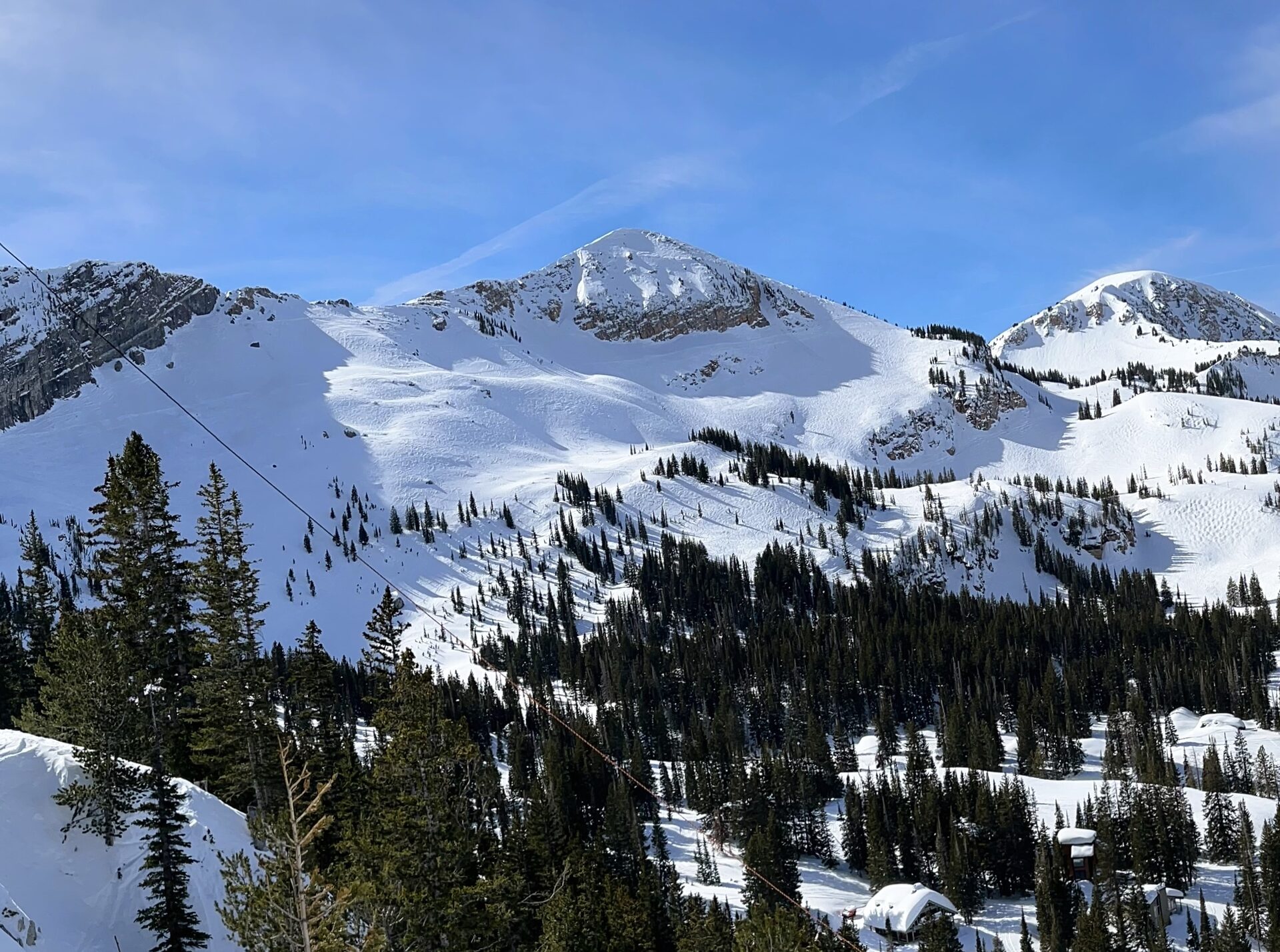 Snow-covered Sugarloaf Mountain and the slopes of Alta under a blue sky, in the Wasatch Range above Little Cottonwood Canyon